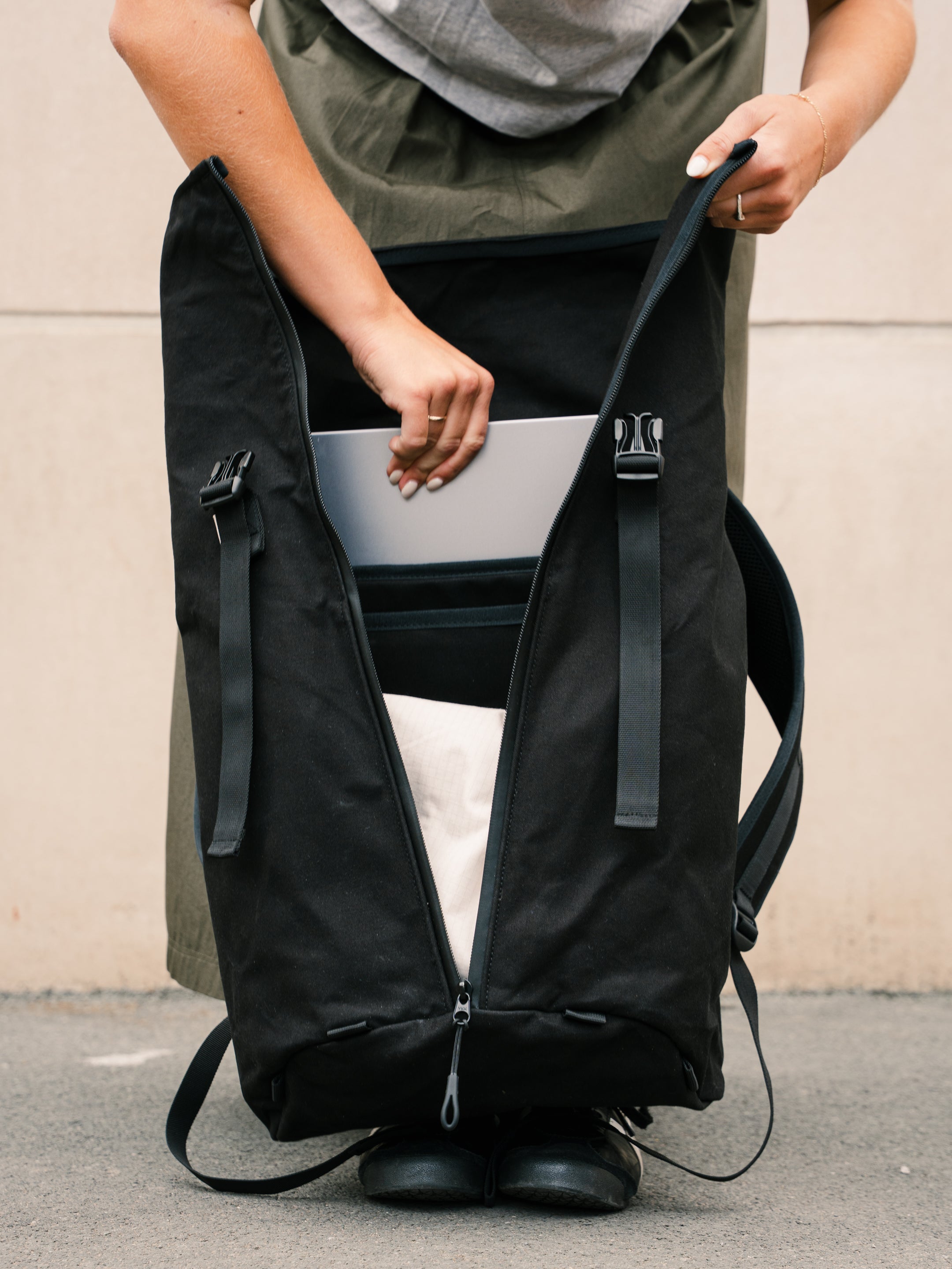 Bridge Backpack in Black with front zip open showing padded laptop compartment